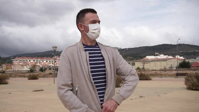 Man wearing reusable face mask in an urban background.
