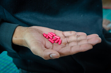 red capsule on hand