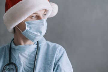 doctor in medical mask and santa on gray background with place for text