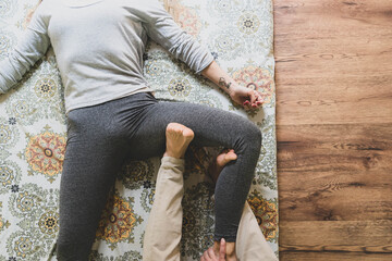 A tattooed masseur performs a Thai massage. Vintage effect, close up