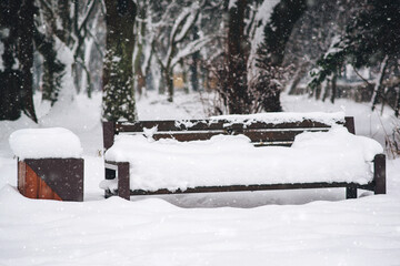 Wooden bench in the snow. Snowy cold winter weather.