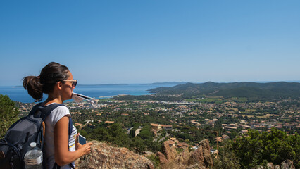 Girl with a map in her mouth watching at the panoramic view