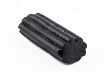 Macro shot of black licorice candy, isolated on a white background.