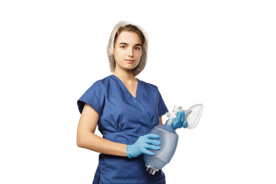 Young beautiful woman doctor in blue surgical gown and gloves holds in hands Am-bu bag for artificial lung ventilation isolated on white background