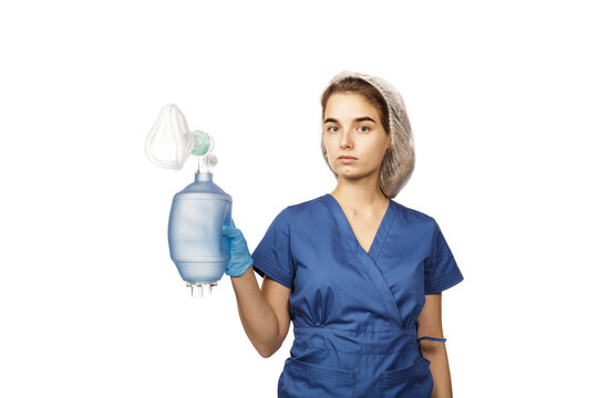 Young beautiful woman doctor in blue surgical gown and gloves holds in hands Am-bu bag for artificial lung ventilation isolated on white background