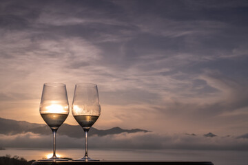 Two glasses of white Wine on a panoramic rooftop at sunset