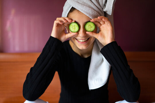 Woman with two cucumber slices on her eyes. - Powered by Adobe