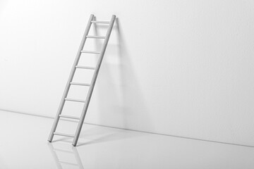 Wooden staircase near the wall in an empty white room. © Denis Rozhnovsky