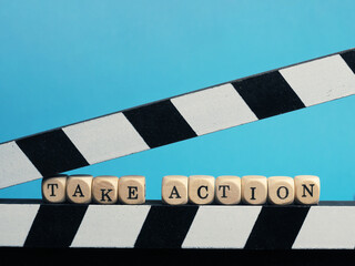Small wooden blocks with the inscription Take Action on a clapperboard, business or entertainment...