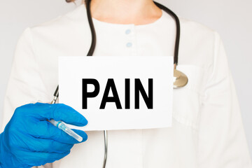 The doctor's blue - gloved hands show the word PAIN - . a gloved hand on a white background. Medical concept. the medicine