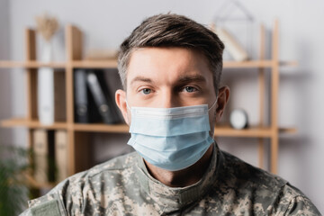 military man in uniform and medical mask looking at camera