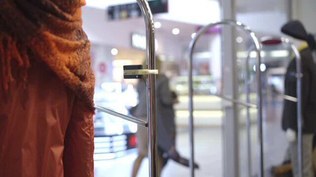 Adult Caucasian woman in Covid-19 face mask running away from shop with stolen clothes. Blond lady stealing goods in shopping mall during coronavirus pandemic global bankruptcy. Covid crisis.