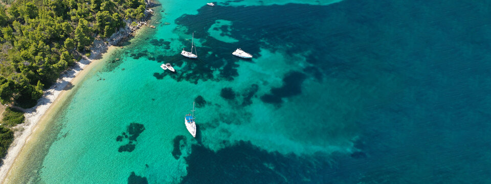 Aerial ultra wide panoramic view of tropical paradise rocky bay visited by sailboats and yachts in Caribbean exotic destination island © aerial-drone