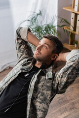 Obraz premium military man in uniform and headset resting on chair