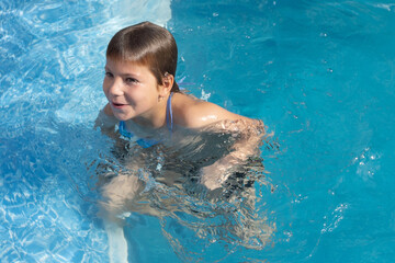 Fototapeta na wymiar child boy stay in swimming in pool outdoor alone
