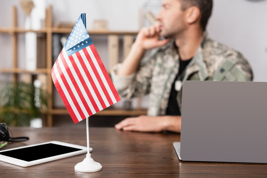 American flag and digital tablet with blank screen near military man in uniform on blurred background - Powered by Adobe