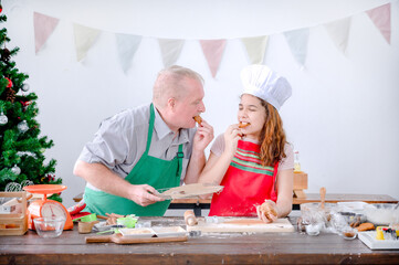 A young European girl and her father tests out the gingerbread she does during Christmas and New Years