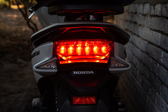 Motorbike Honda stands in the dark with the rear light on.