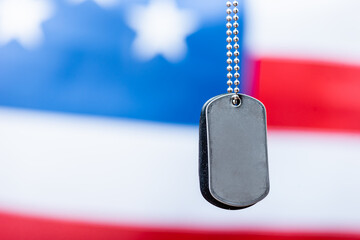 Fototapeta premium close up of blank metallic badge on chain near american flag on blurred background