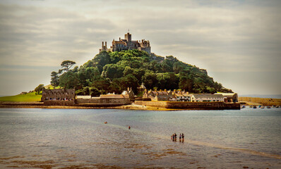 People walking across causeway to St. Michael's Mount at low tide. Historical island dating back not 495 A.D.