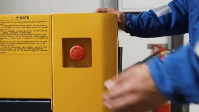 Hand of worker pushing red emergency button STOP. Equipment shutdown in case of