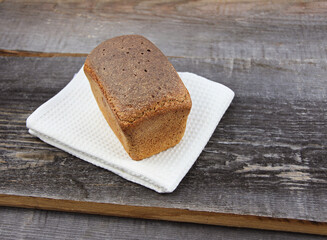 Homemade rye sourdough bread with a crisp crust on a rough Board background.
