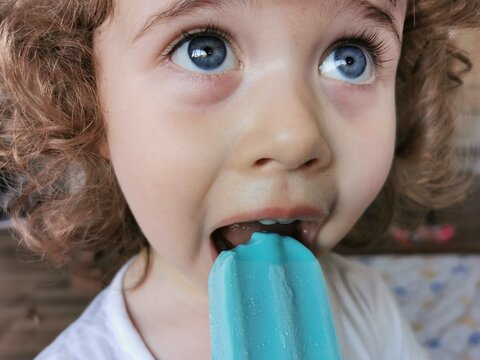Little girl enjoying her blue Popsicle