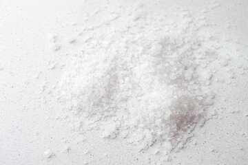 Heap of white sea salt on the marble table. Top view.