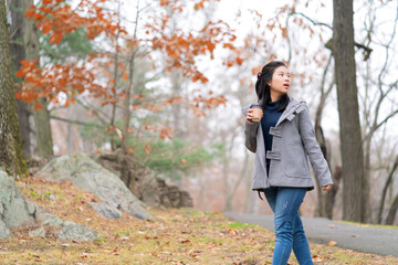 asian female woman in winter cloth relax enjoy walking in the forest park peaceful and tranquility nature background concept