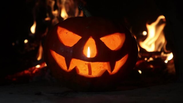 pumpkin head with a candle in the nose on the background of the fire