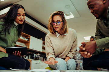 Diverse group of colleagues gather together to cover project presentation sitting in office lounge before presentation 