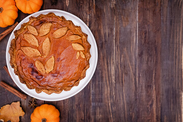 Homemade pumpkin pie on wooden table. Thanksgiving treat, autumn dessert