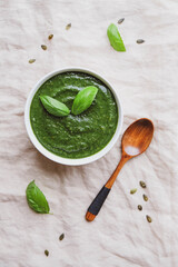 A bowl of hot healthy green vegetable cream soup, from above.