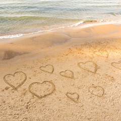 Symbols of the hearts drawing on the sand on the beach.