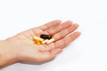 close-up of a young female hand on which are pills, vitamins of yellow, white, black color. Coronavirus, pandemic, pharmaceuticals, medicine. Protection from infection