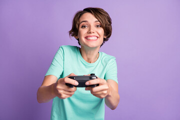 Photo of cute funny young lady wear casual teal outfit holding playing console isolated purple color background