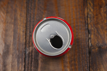 Top view of opened aluminum can of beer or soda on the dark wooden backgound