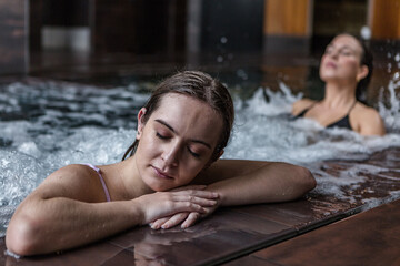 Relaxed woman getting hydro massage therapy in pool