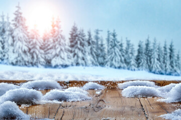 Wooden table and fluffy snow surrounded by a beautiful winter landscape