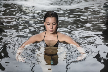 Slim woman relaxing in water in spa center