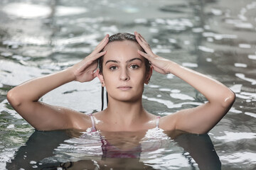 Young woman with perfect skin relaxing in pool