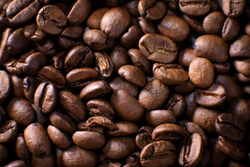 Coffee beans close up against the background of a coffee beans. Morning espresso. Coffee mug. 