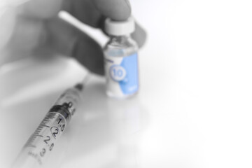 syringe and vaccine bottle in hand