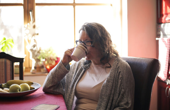 woman drinks a cup of coffee at home