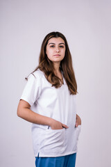 female dentist staring into the camera. Her hands are in the pockets of her white coat