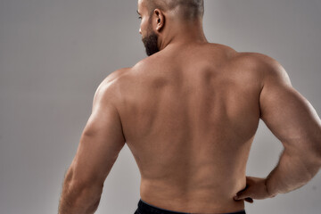 Young muscular caucasian bodybuilder showing strong back