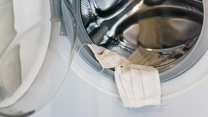 white coronavirus textile fabric mask into the washing machine