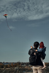 A man with a two-year-old child is flying a kite. Games with children, fatherhood.