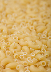 Fresh raw classic maccheroni elbows pasta ias texture background.