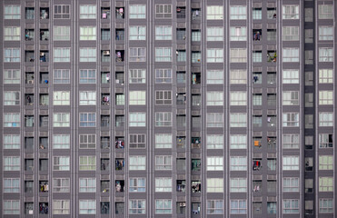 Fototapeta na wymiar Windows and balcony of brown high rise living space condominium with cloth hanging on a clothes line at the balcony. Architecture detail shot.